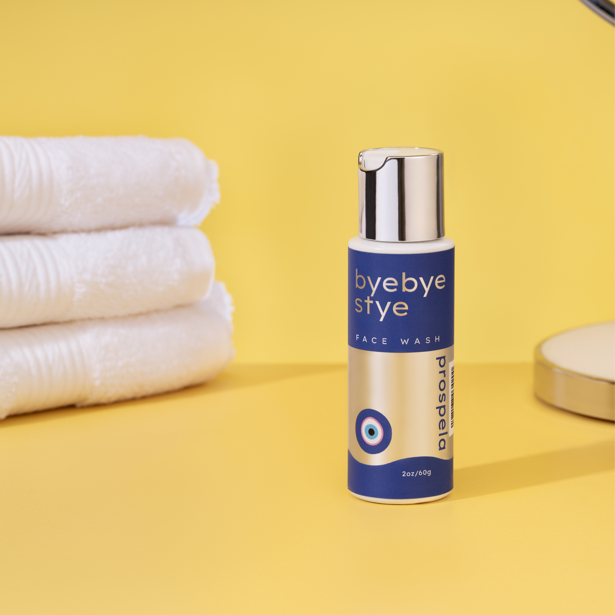 Bye Bye Stye bottle with yellow background and towels 